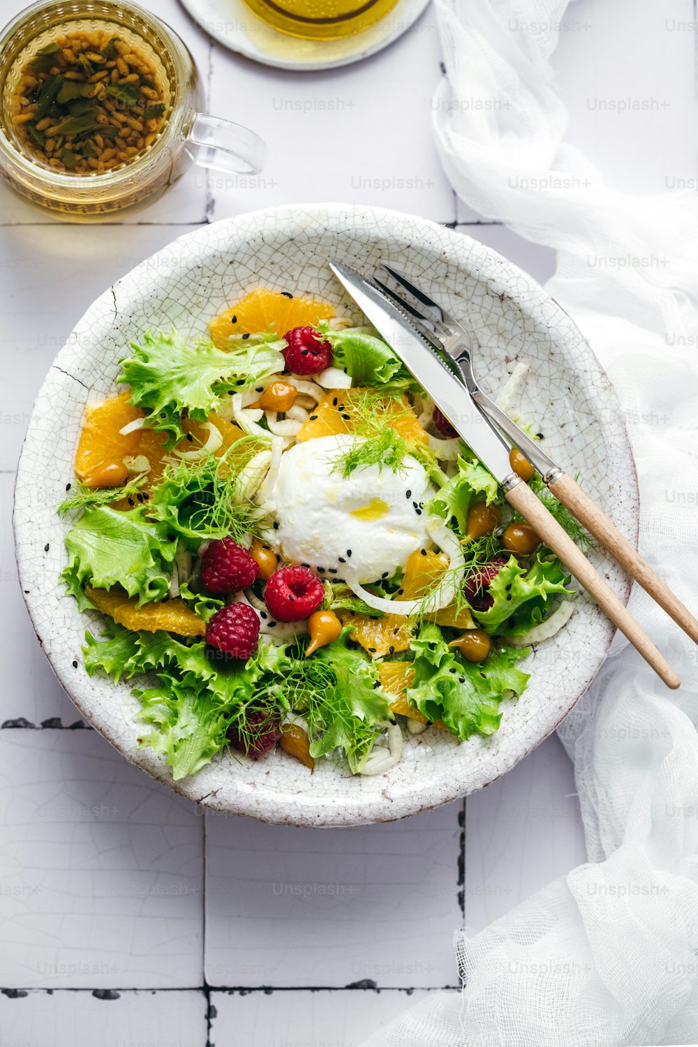 a white bowl filled with a salad and a fork