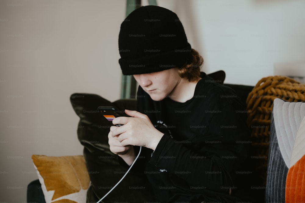 a person sitting on a couch looking at a cell phone