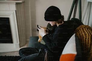 a woman sitting on a couch holding a cell phone