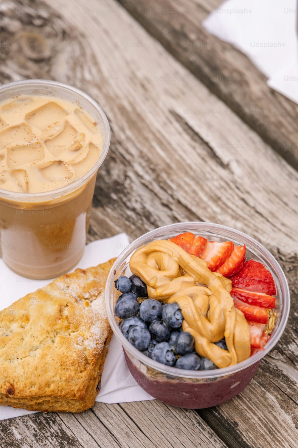 a bowl of fruit and a cup of coffee on a wooden table