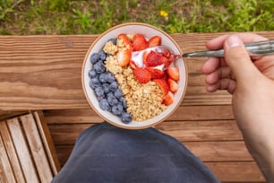 a bowl of cereal with strawberries and blueberries