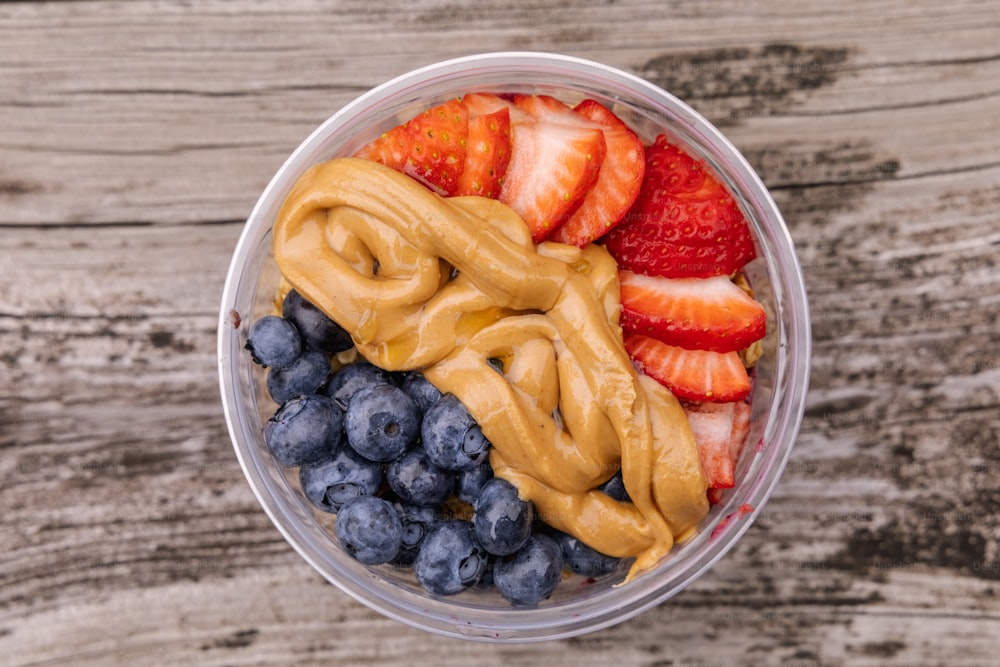 a bowl filled with fruit and pretzels on top of a wooden table