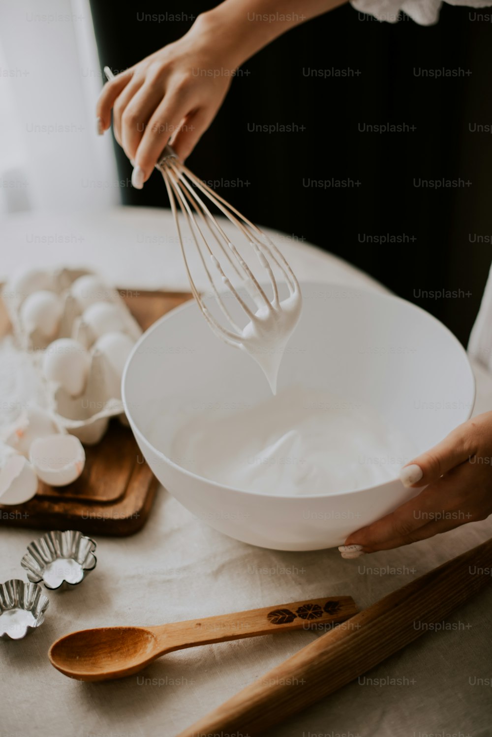 a person whisking eggs in a white bowl