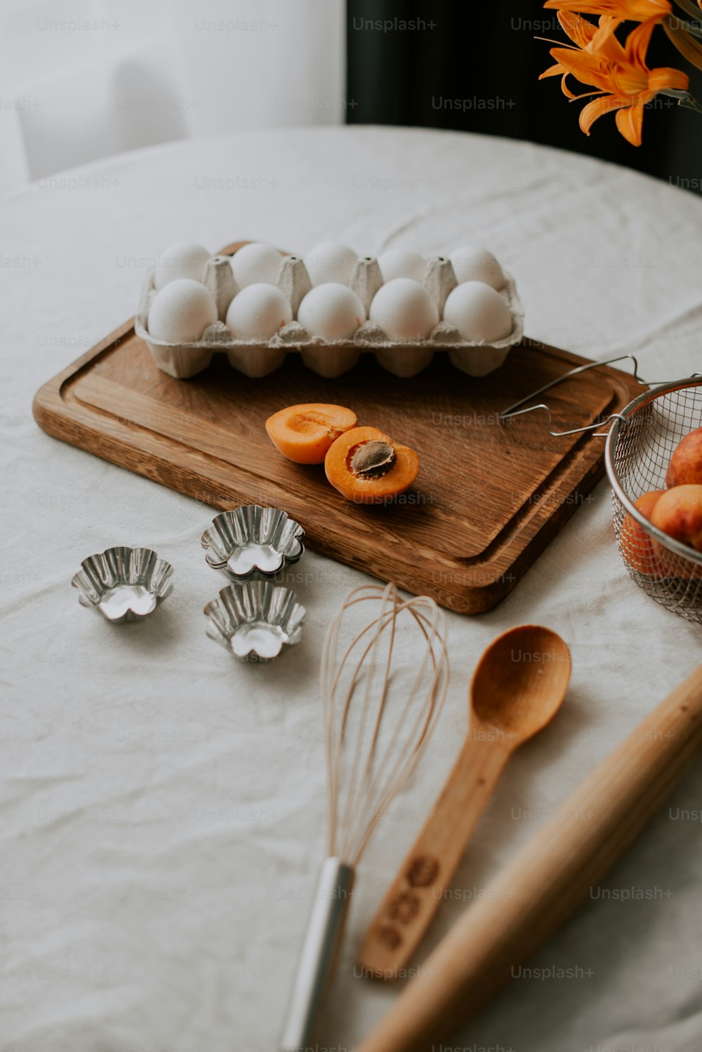 una tabla de cortar de madera cubierta con huevos y naranjas