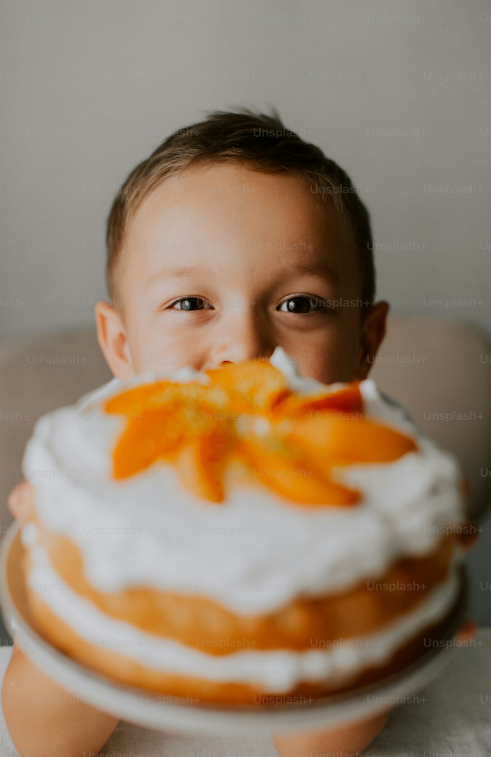 a little boy that is sitting in front of a cake