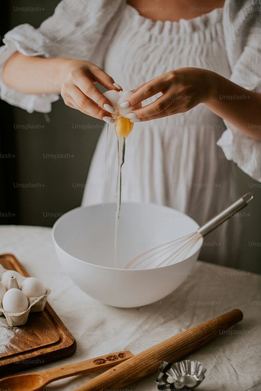 Une femme mélange des œufs dans un bol
