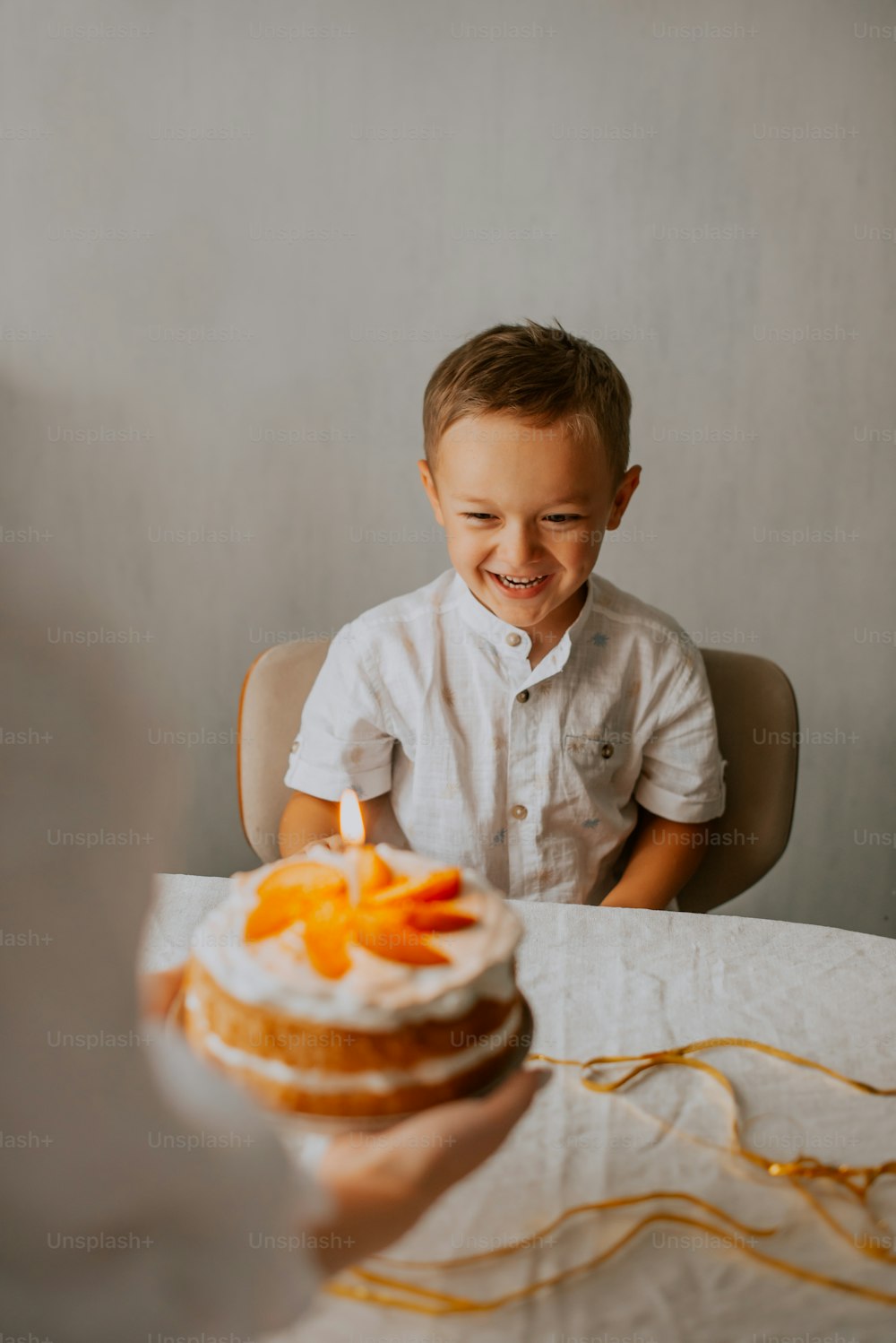 a little boy sitting at a table with a cake
