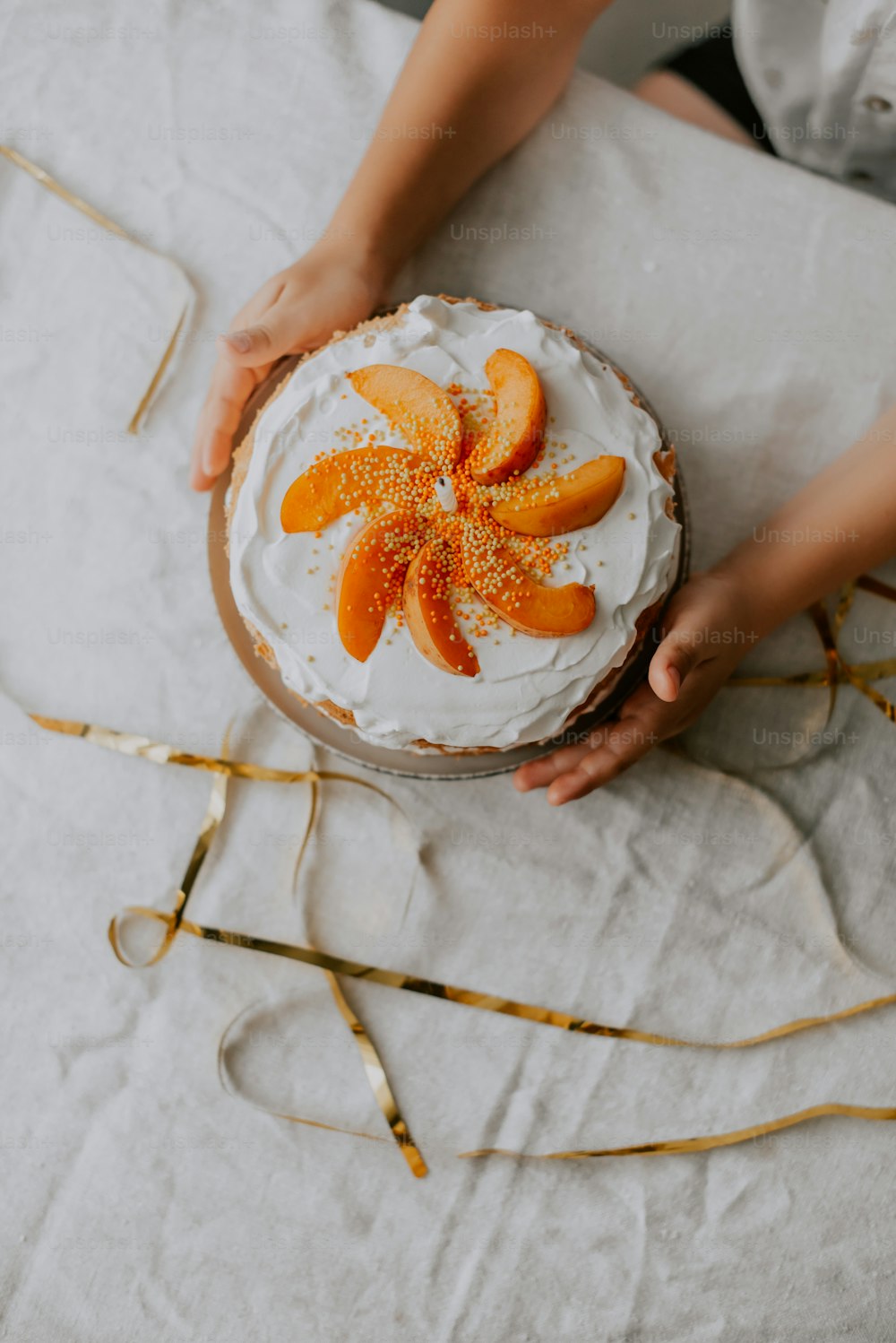 una persona sosteniendo un pastel con rodajas de naranja