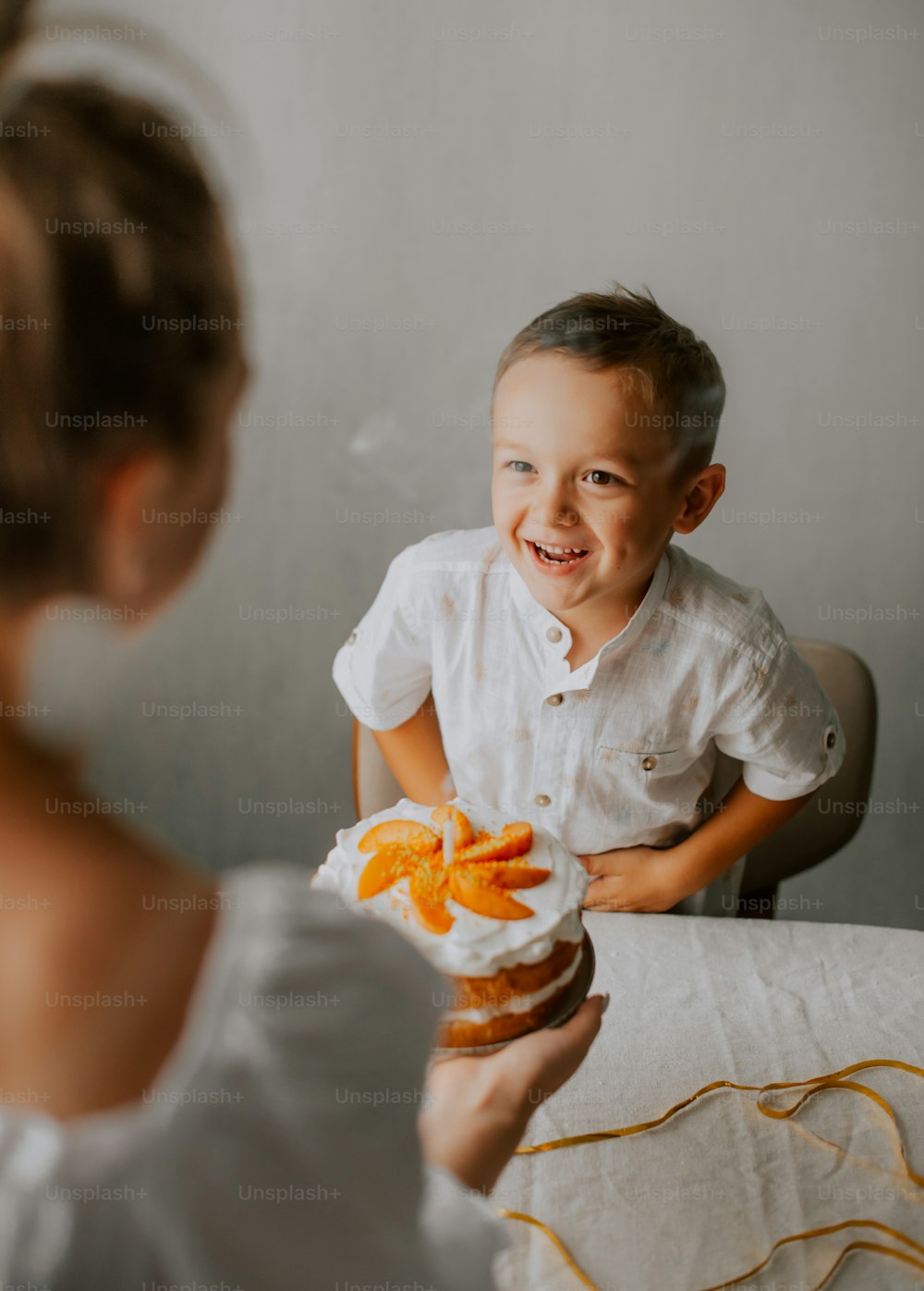 Un niño pequeño sentado en una mesa con comida frente a él