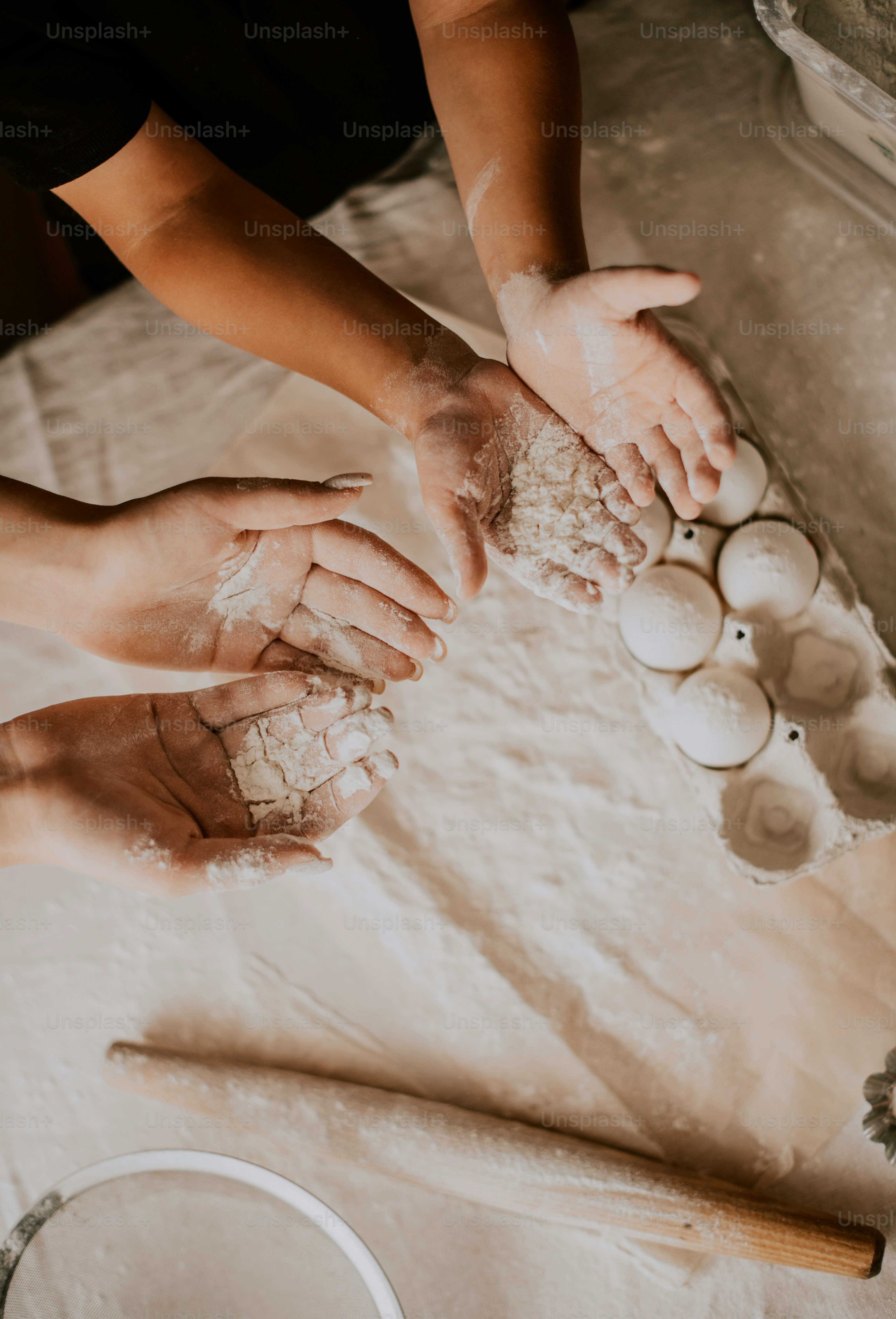 a couple of people are kneading dough on a table