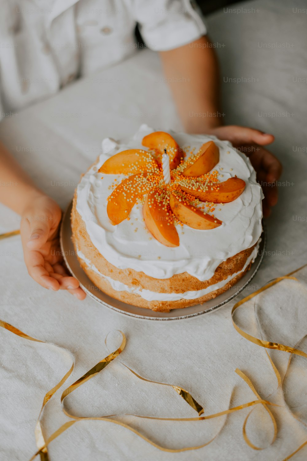 a person holding a cake with orange slices on it