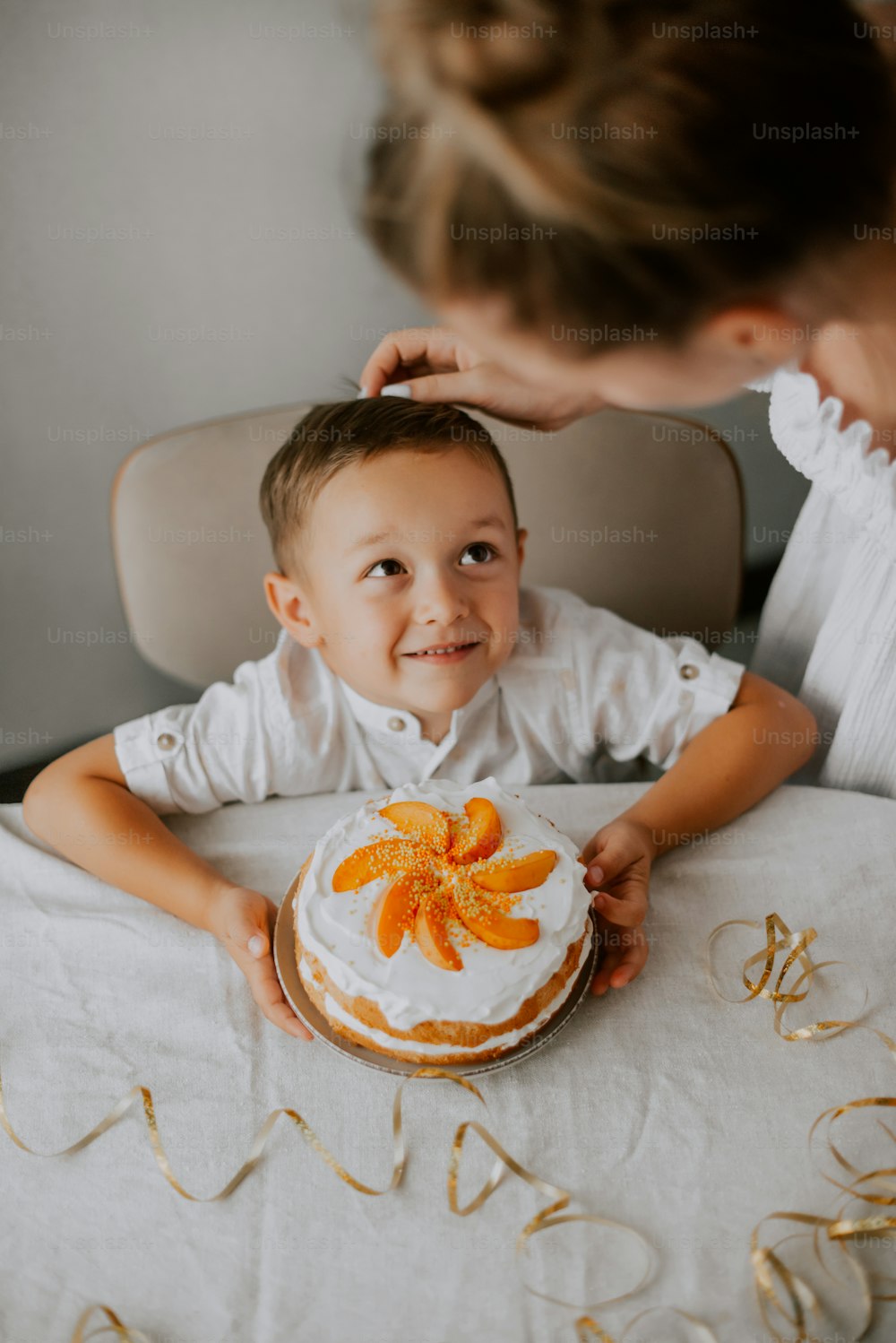 a little boy sitting at a table with a cake