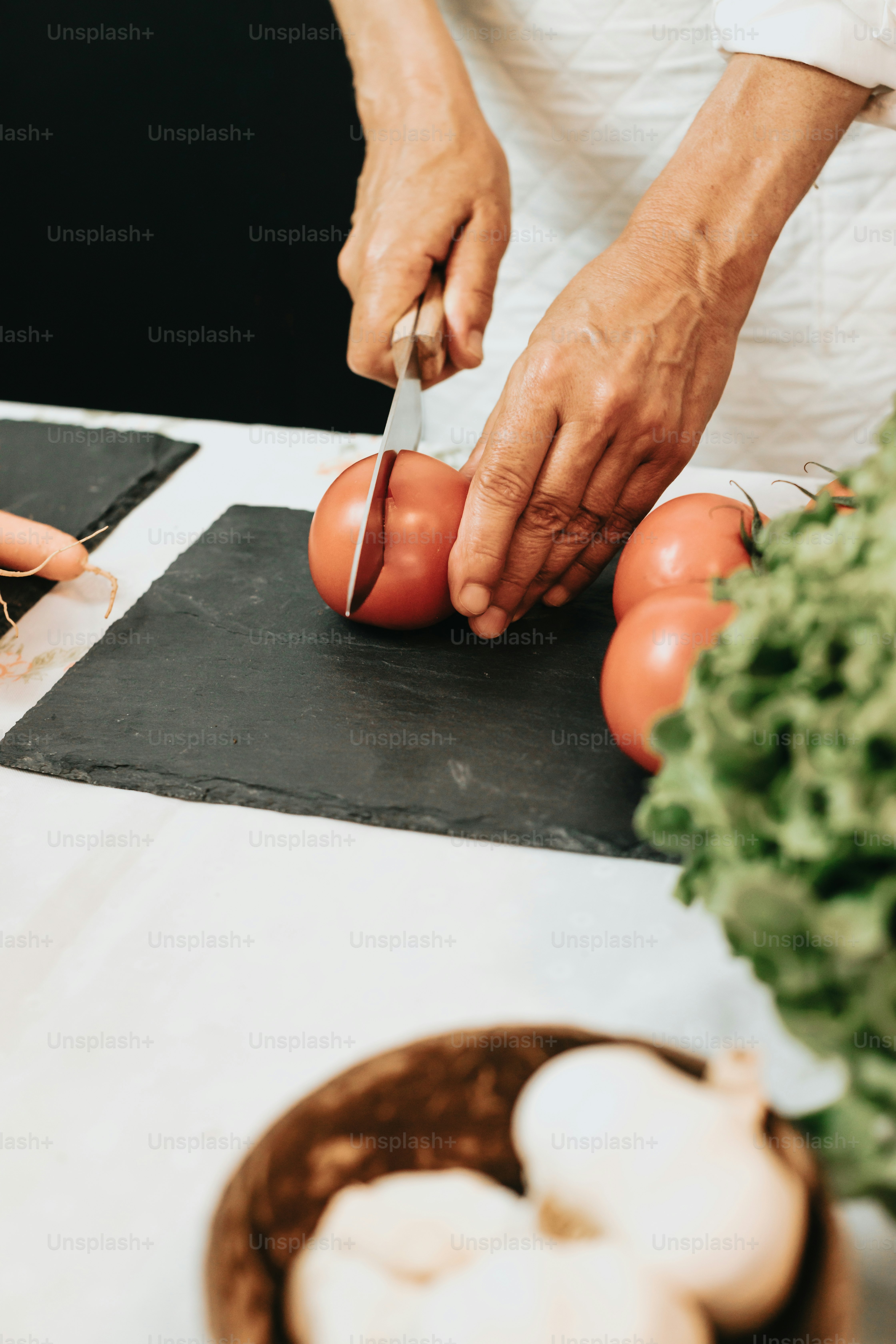Una persona cortando tomates en una tabla de cortar