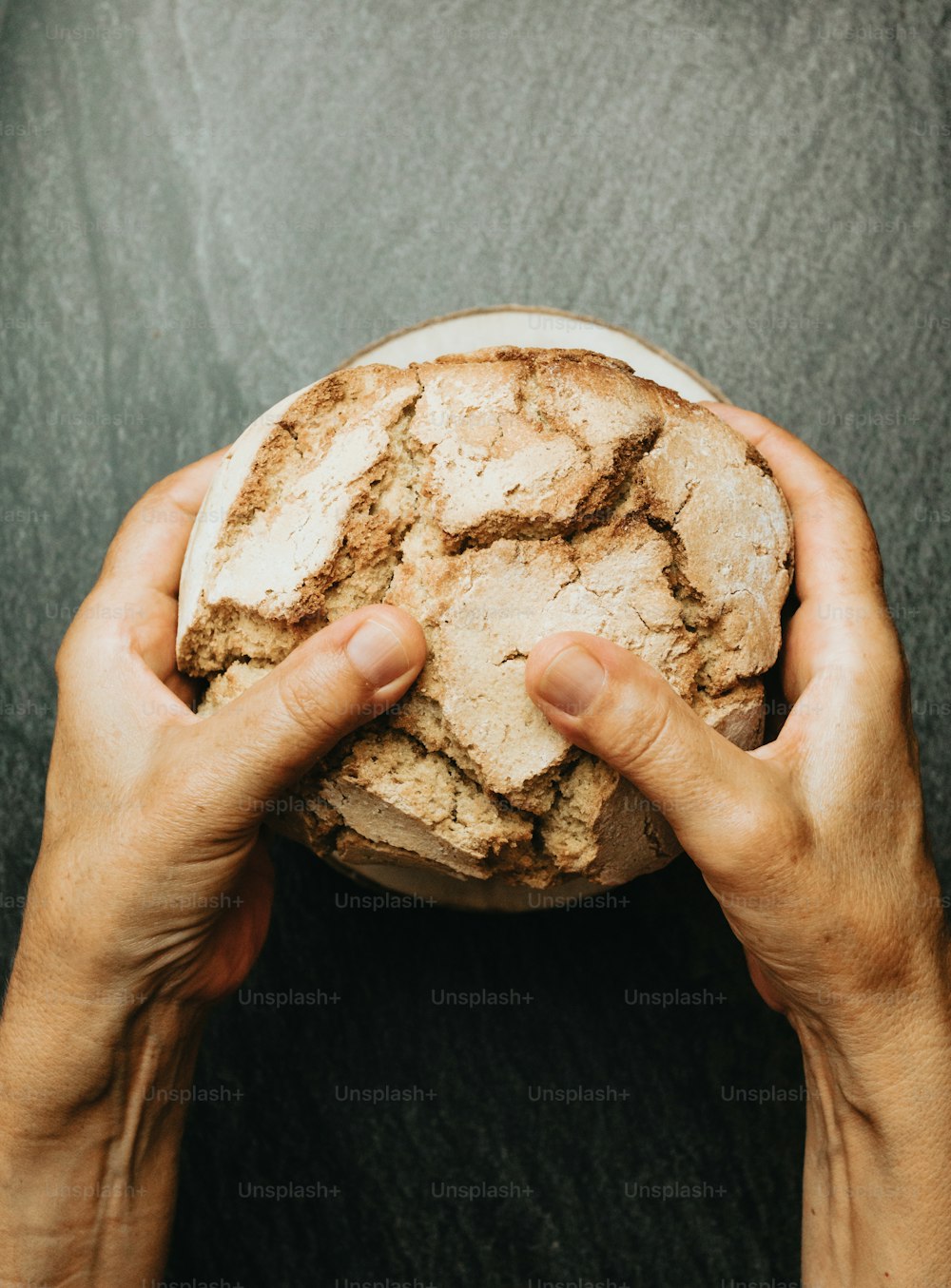 uma pessoa segurando um pedaço de pão nas mãos