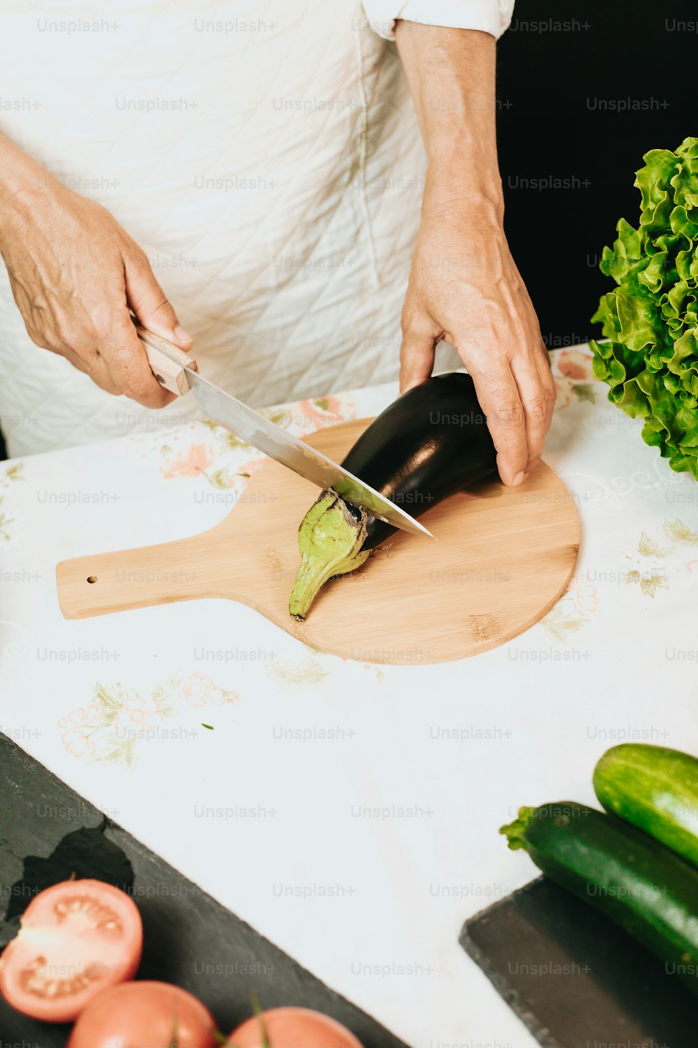 a person cutting up an eggplant on a cutting board