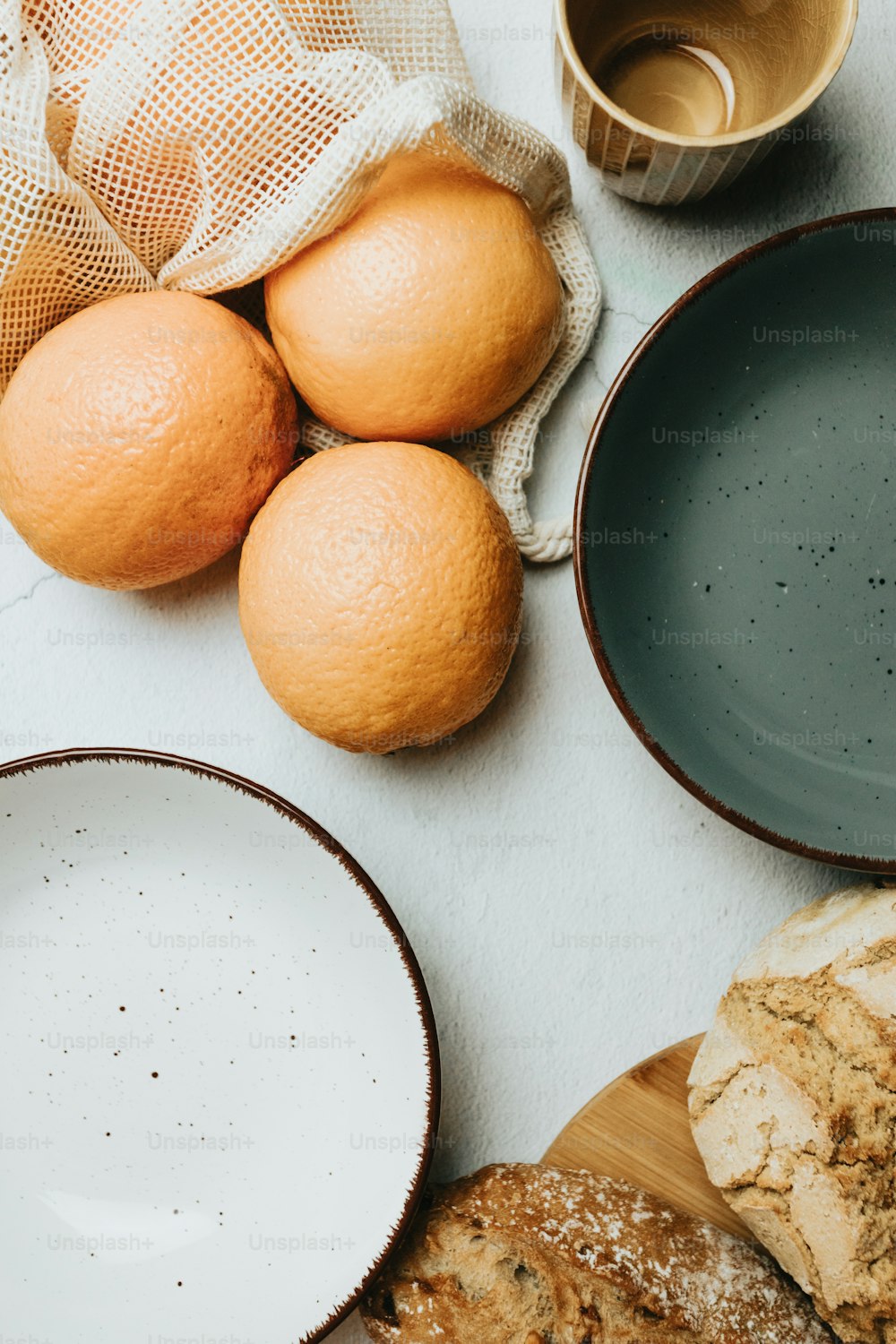 uma mesa coberta com pratos e tigelas cheias de laranjas