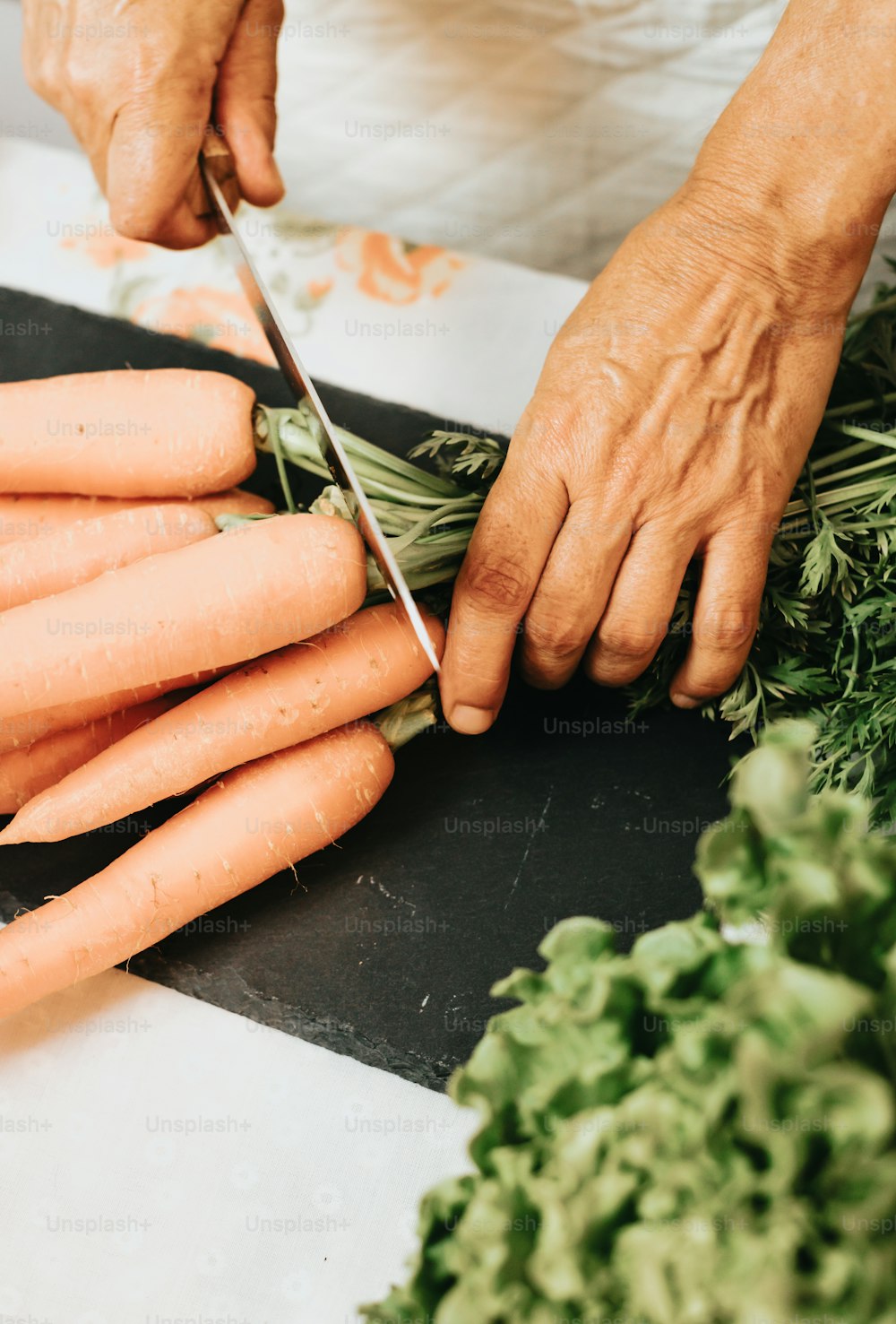 une personne coupant des carottes avec une paire de ciseaux