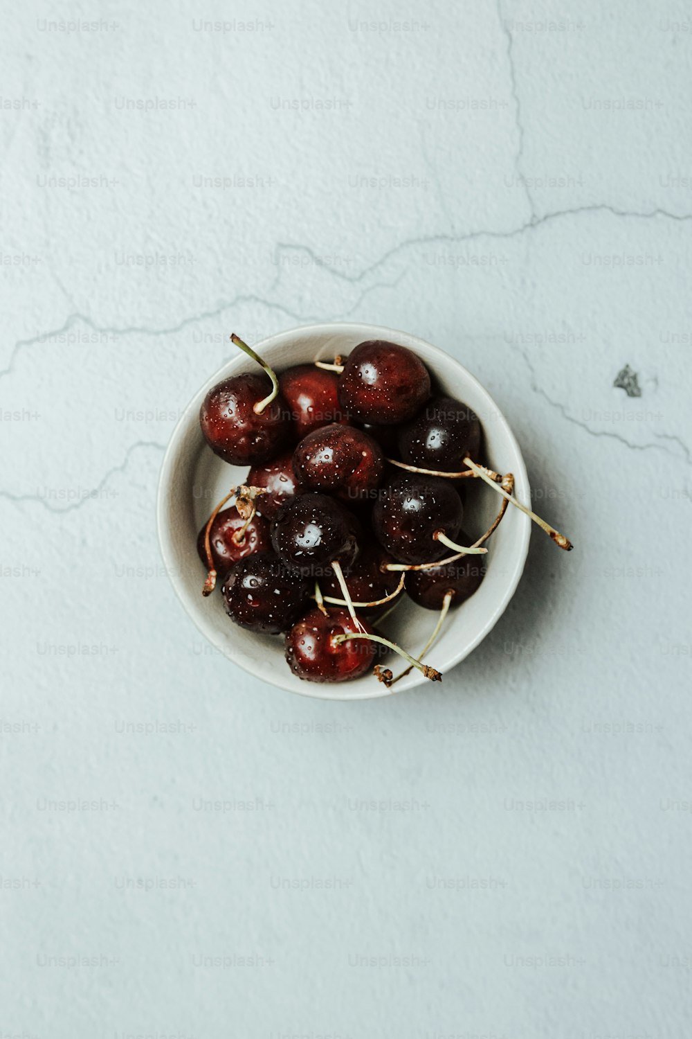 a white bowl filled with cherries on top of a table