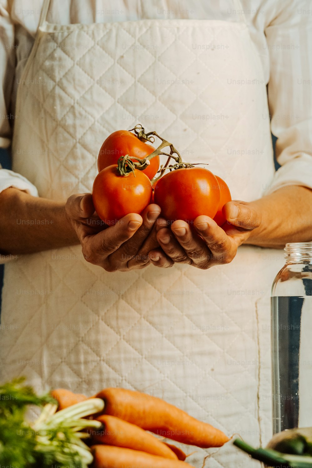 a person holding a bunch of tomatoes in their hands