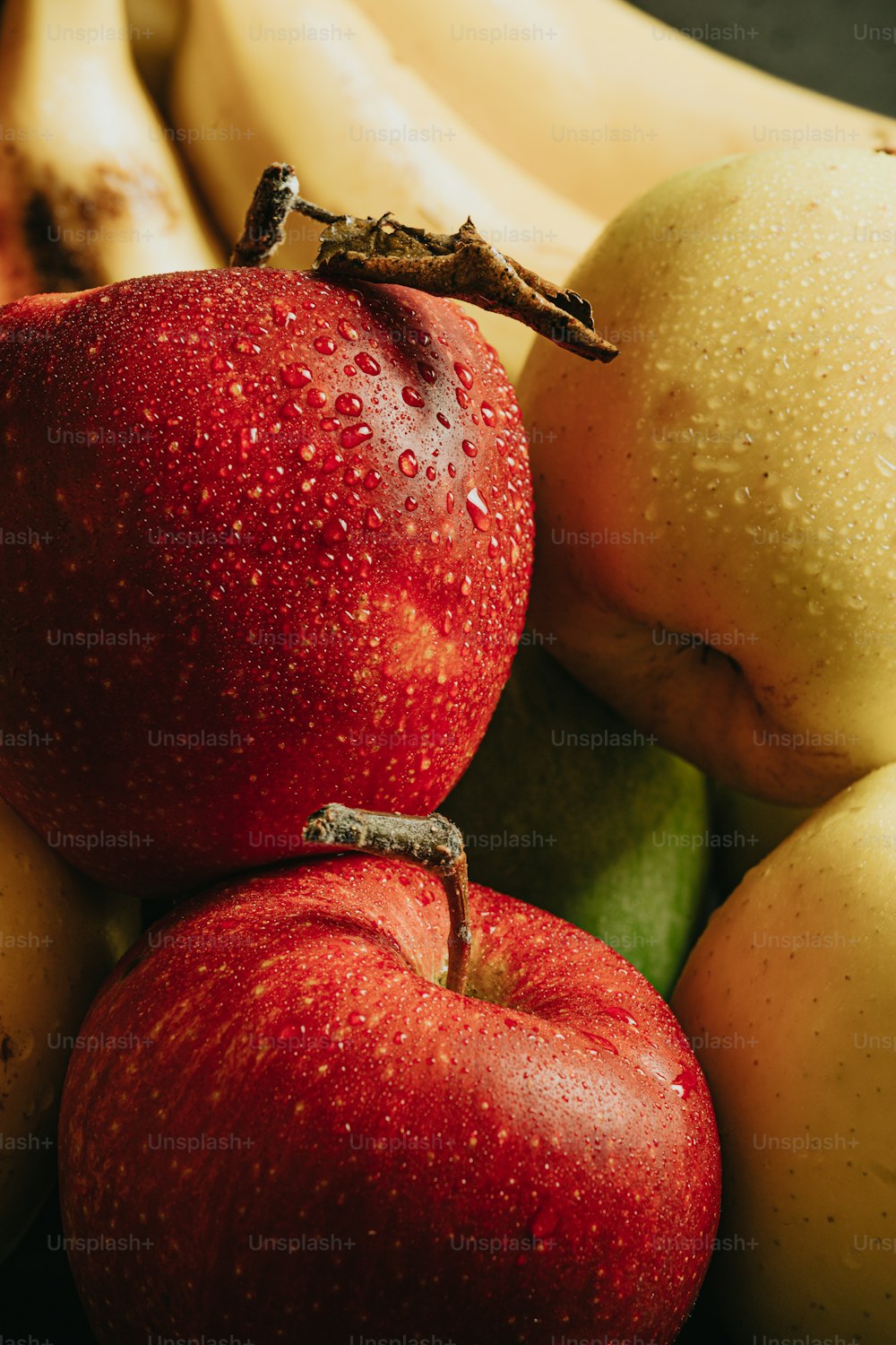 a close up of apples and bananas on a table