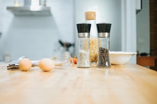 a wooden table topped with salt and pepper shakers