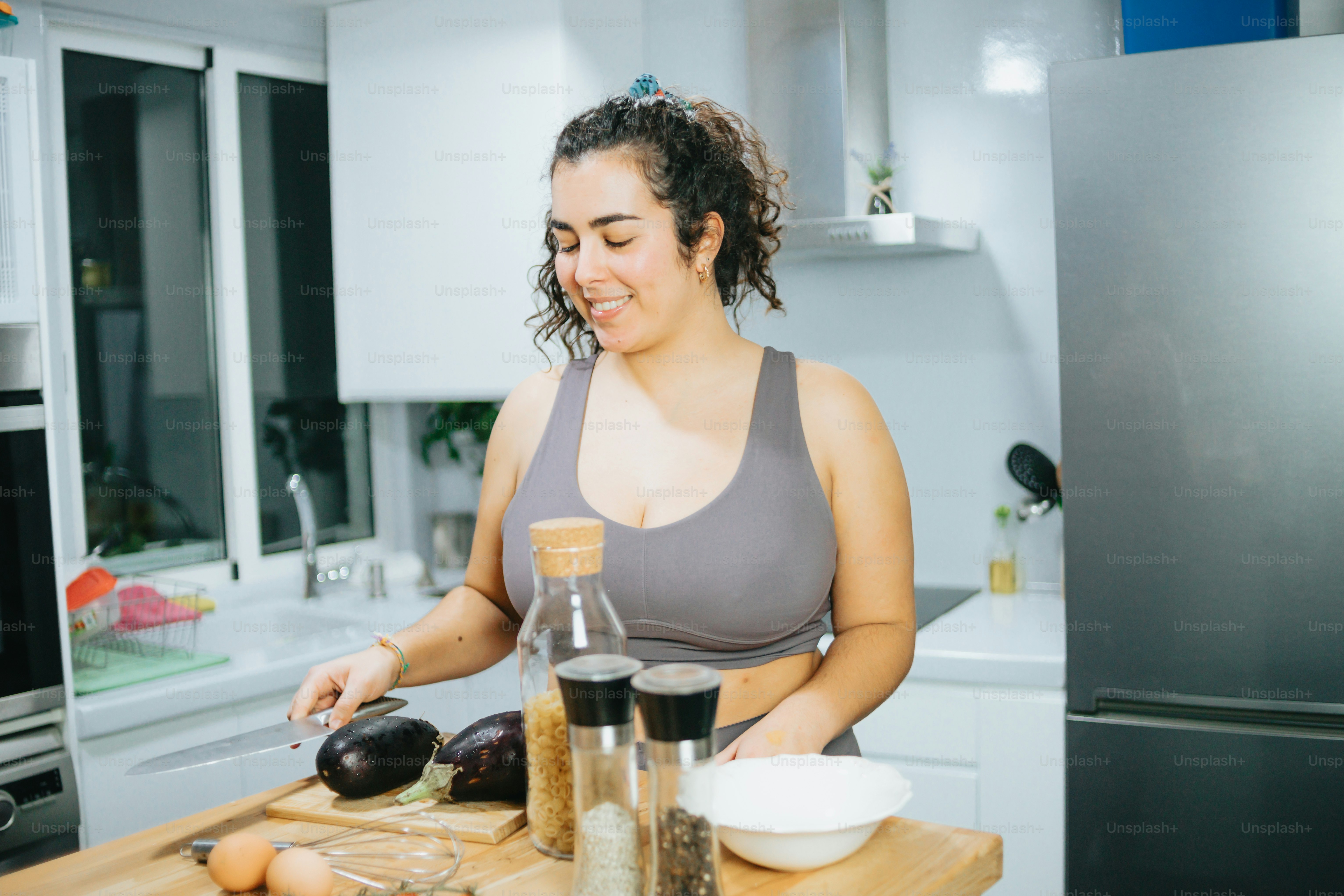 a woman standing in a kitchen preparing food