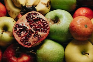 Ein Granatapfel sitzt auf einem Haufen Obst