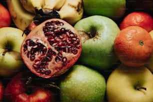 a pomegranate sits on top of a pile of fruit