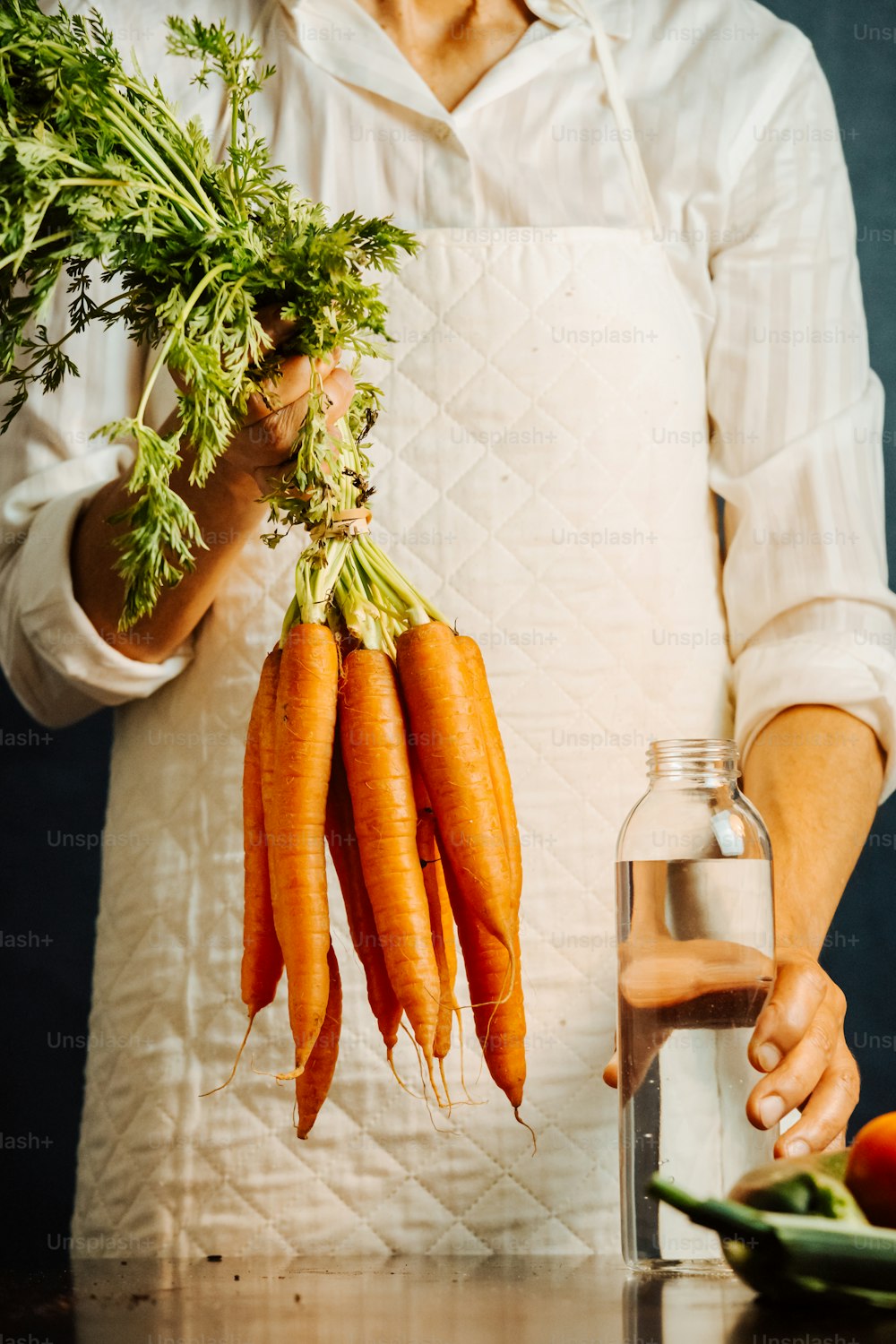 uma pessoa segurando um monte de cenouras nas mãos