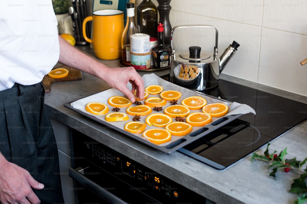 a man is putting orange slices on a tray
