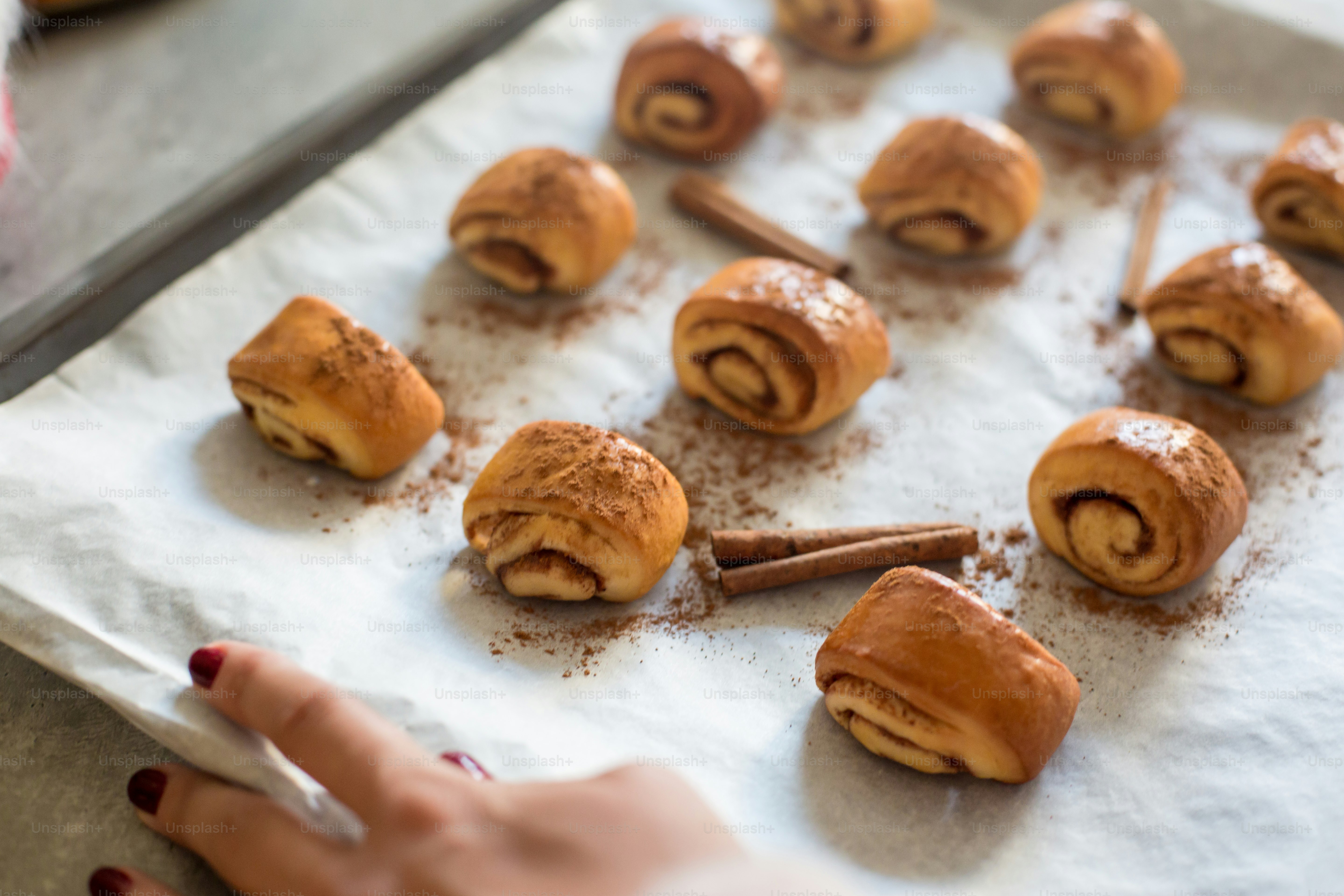 rollos de canela en una bandeja para hornear con palitos de canela
