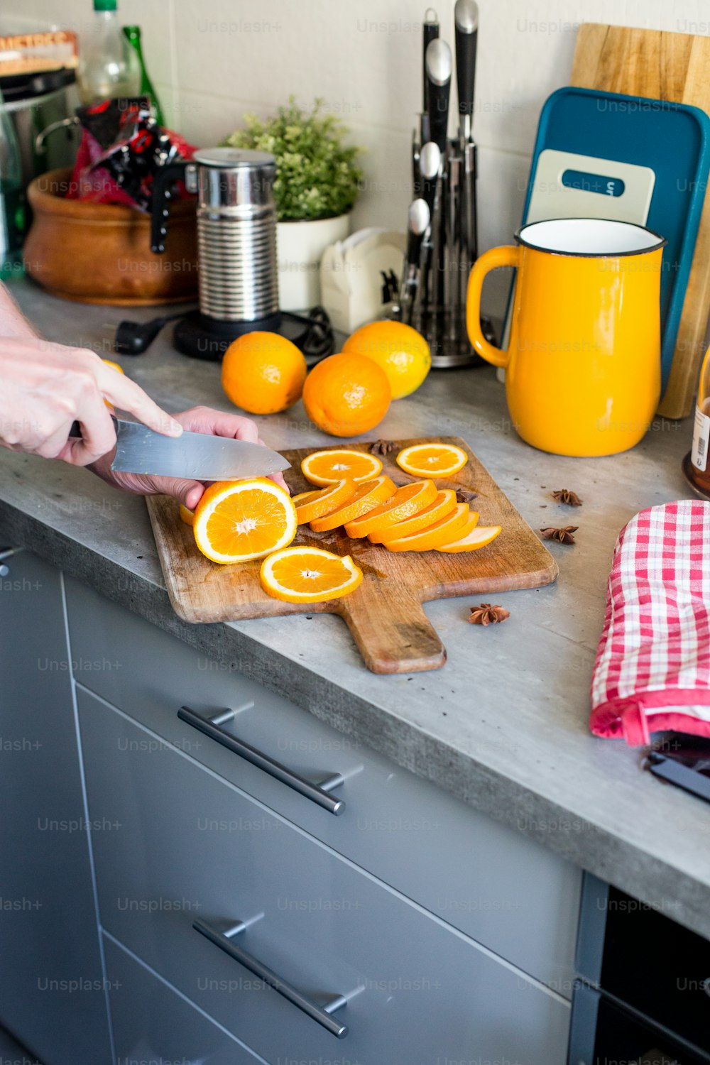 uma pessoa cortando laranjas em uma tábua de corte