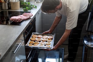 a man putting food into an oven in a kitchen