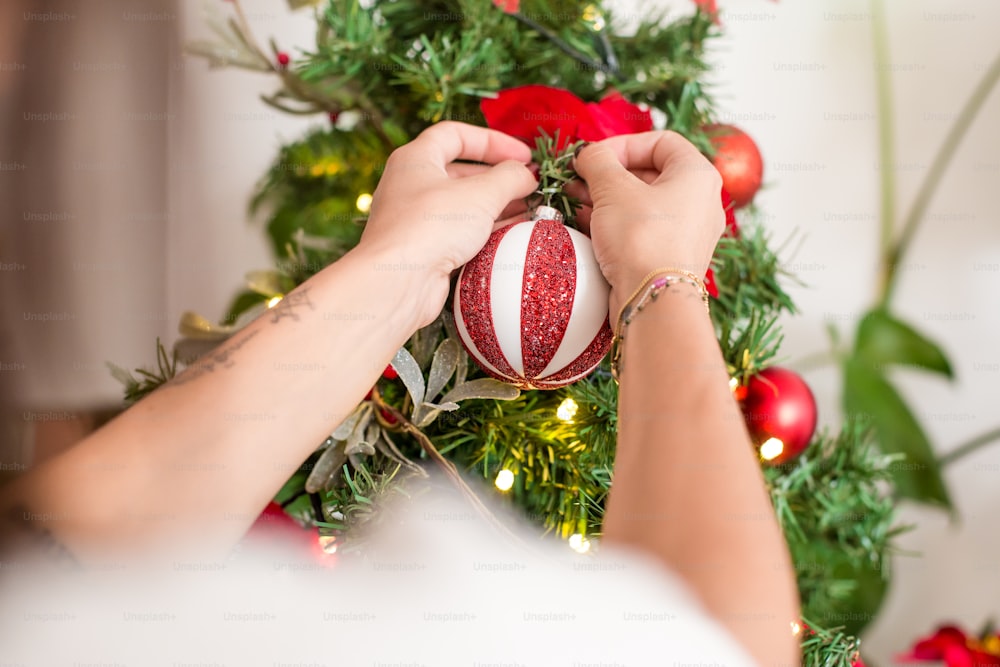 Una donna che decora un albero di Natale con ornamenti
