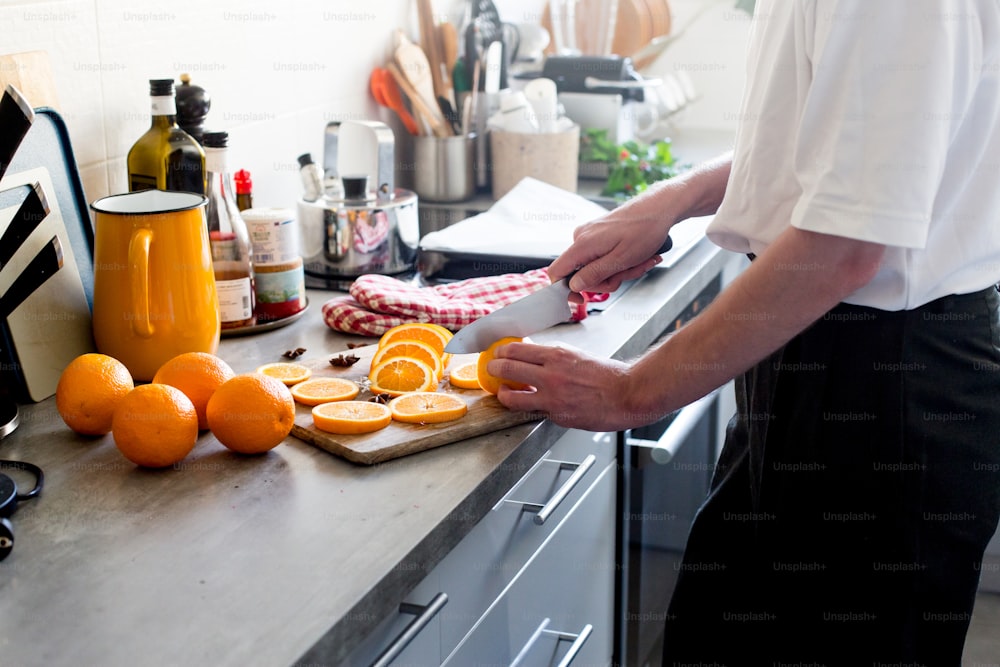 a person cutting oranges on a cutting board