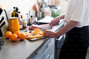 a person cutting oranges on a cutting board