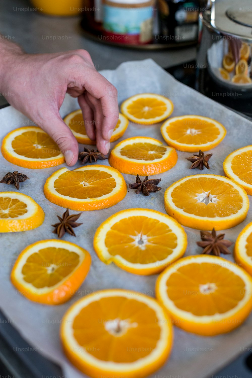 a person reaching for an orange on a baking sheet