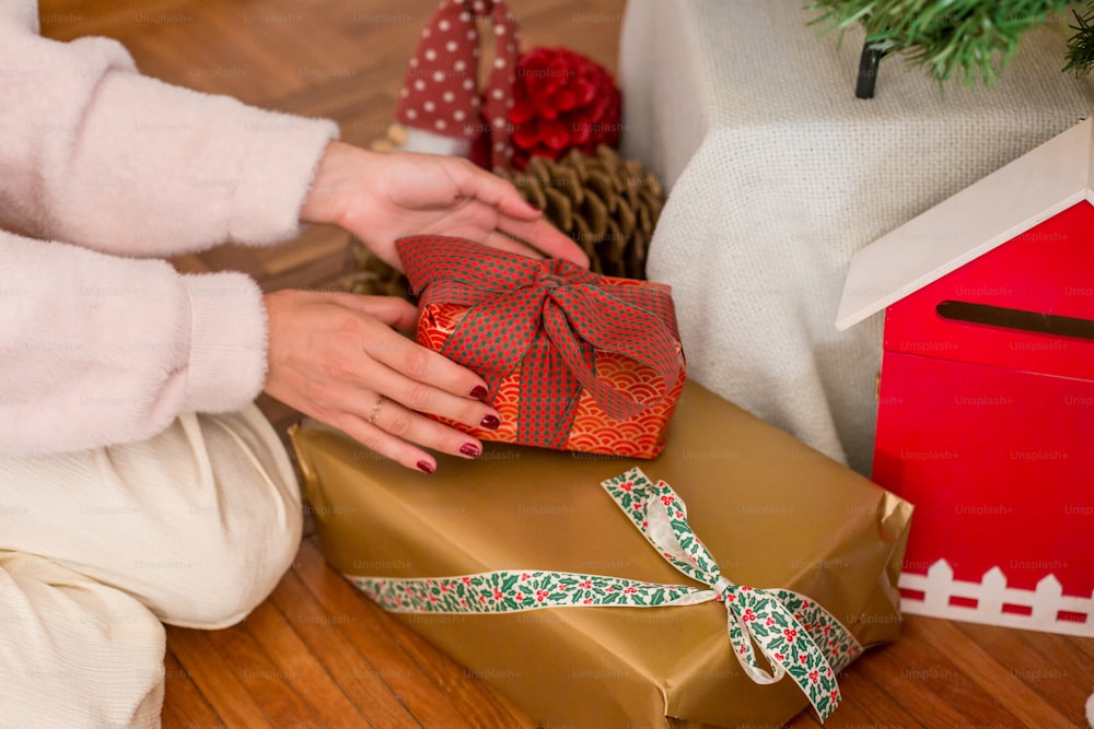 Eine Frau, die eine verpackte Geschenkschachtel auf dem Boden öffnet