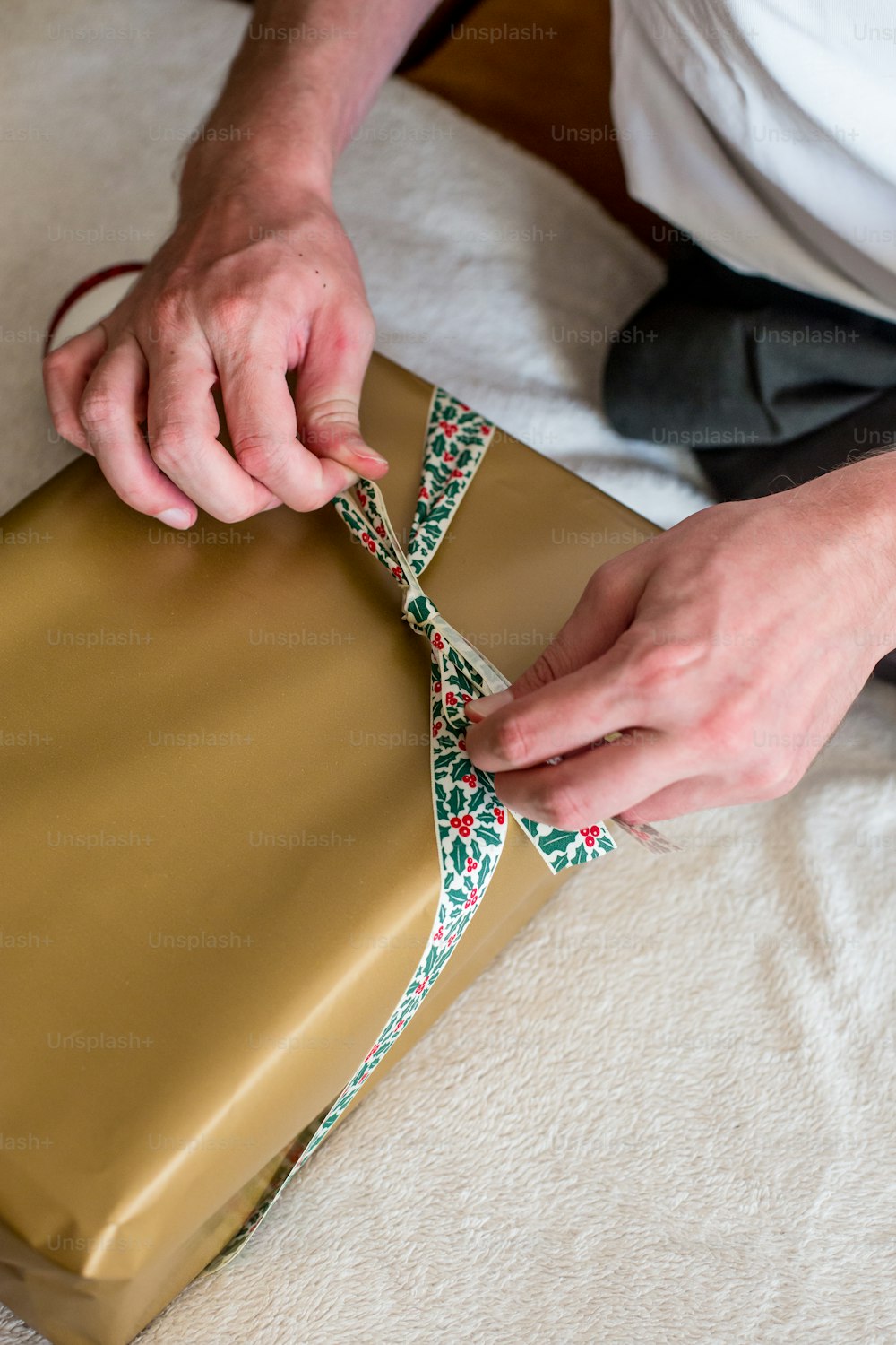 a person wrapping a present on a bed