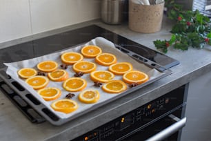 a tray of oranges sitting on top of a stove