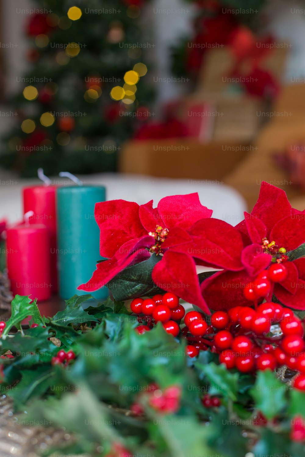 a table topped with red poinsettias and greenery