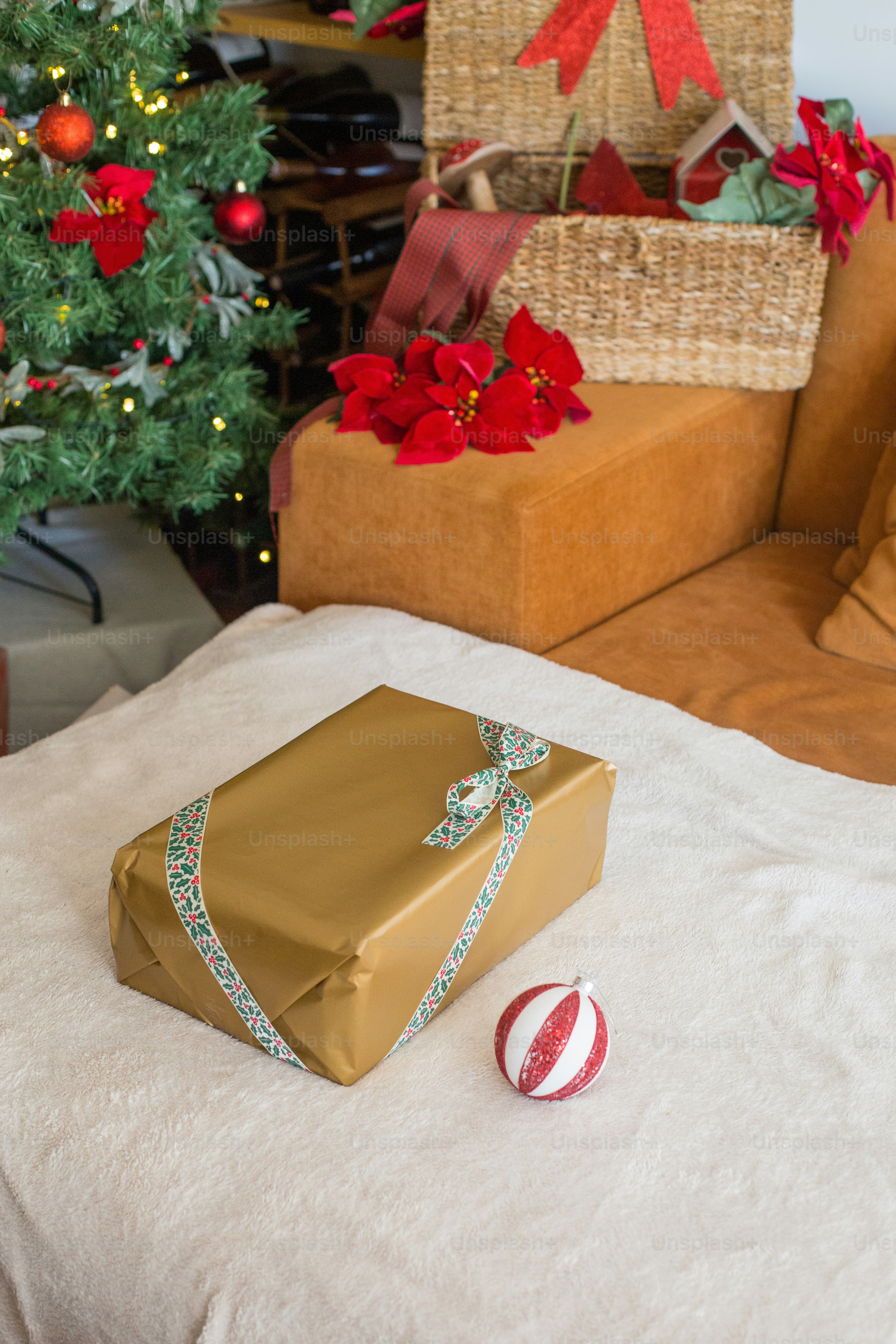 a wrapped present sitting on a bed next to a christmas tree