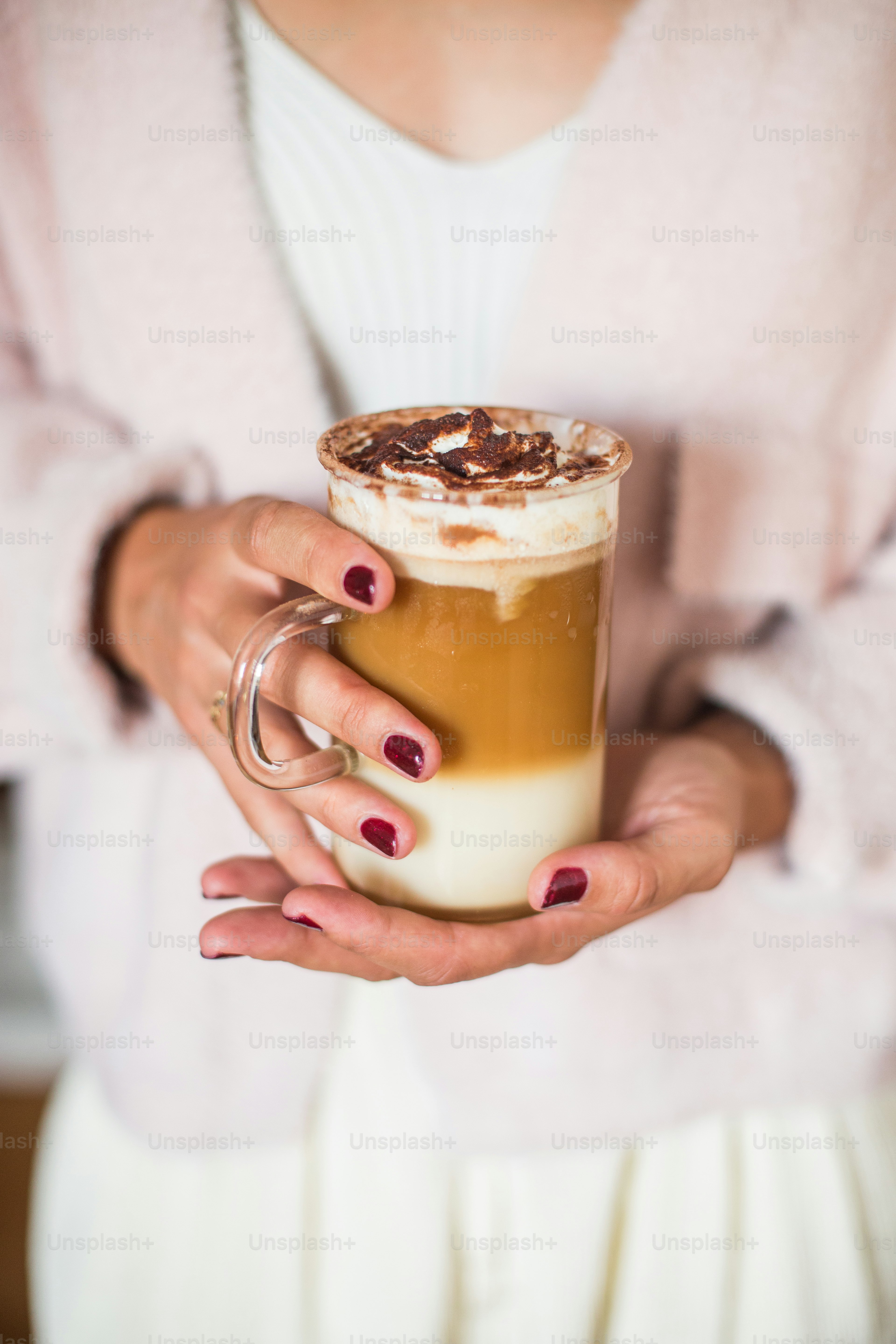Una mujer sosteniendo una bebida en sus manos