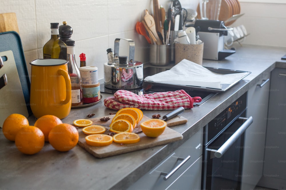 un comptoir de cuisine surmonté d’oranges et une planche à découper