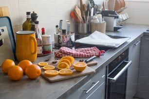 um balcão de cozinha coberto com laranjas e uma tábua de corte