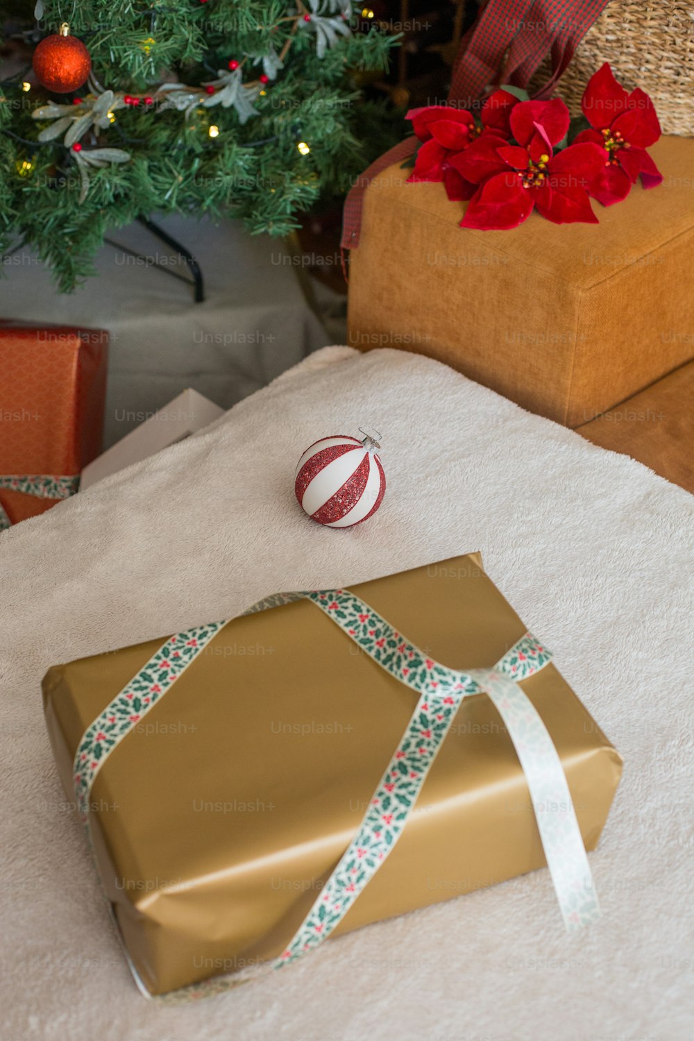 Um presente embrulhado sentado em uma mesa ao lado de uma árvore de Natal