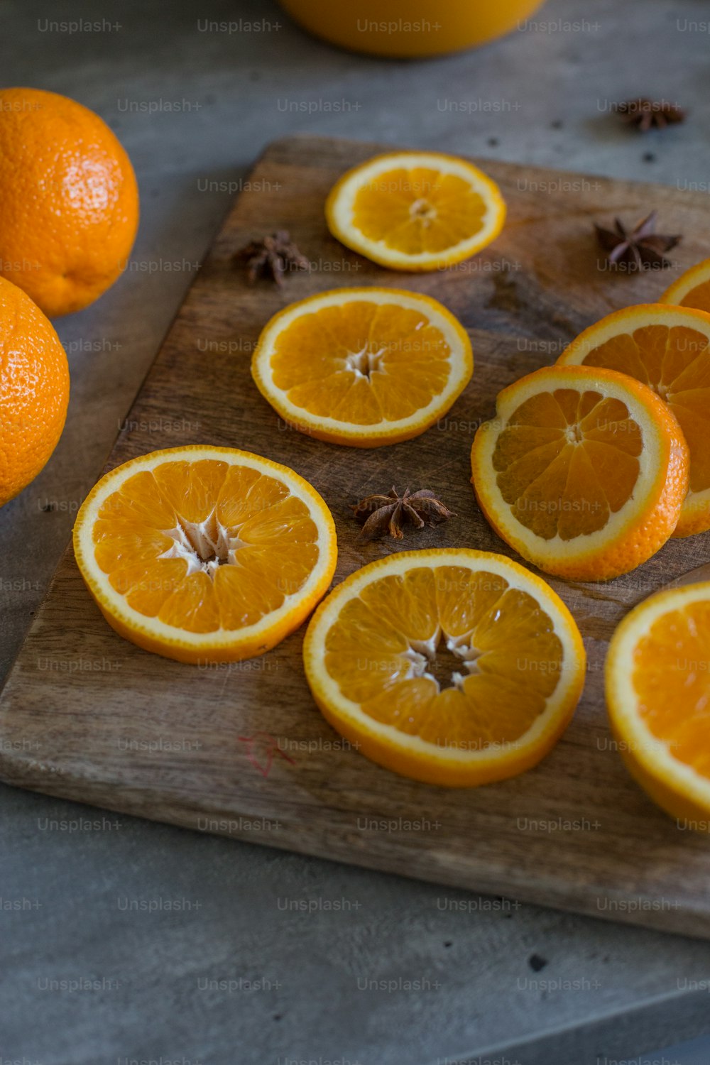 a cutting board topped with sliced oranges on top of a table