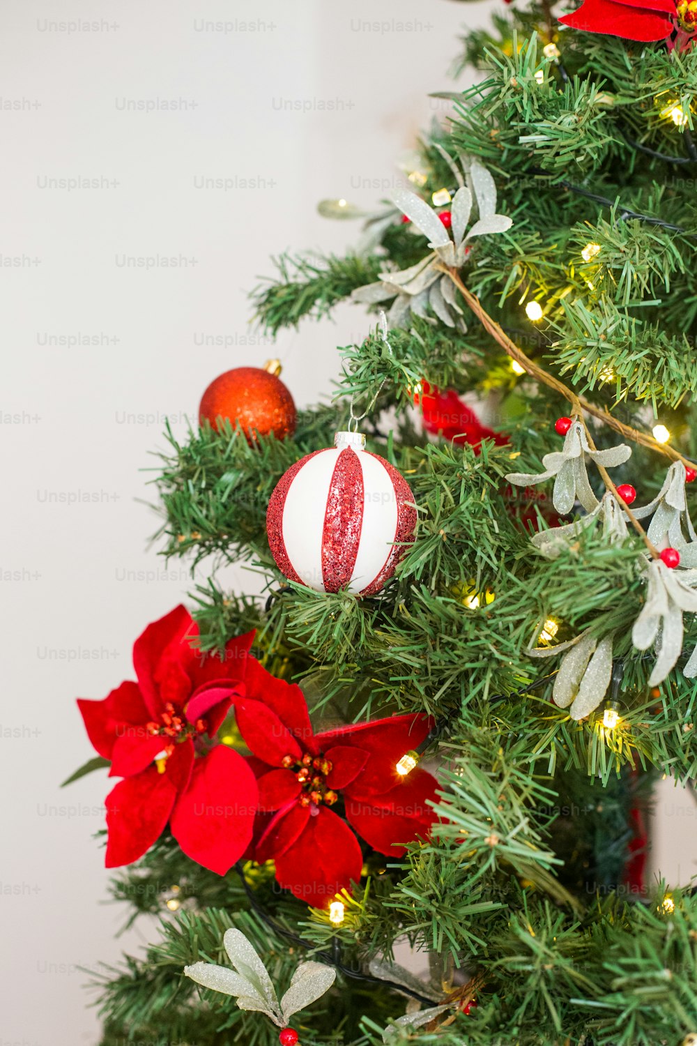 Uma árvore de Natal decorada com ornamentos vermelhos e brancos