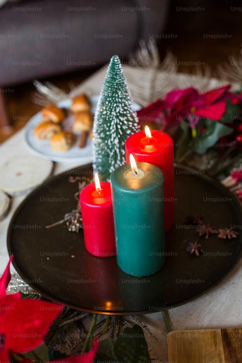 three candles on a plate with a christmas tree on top
