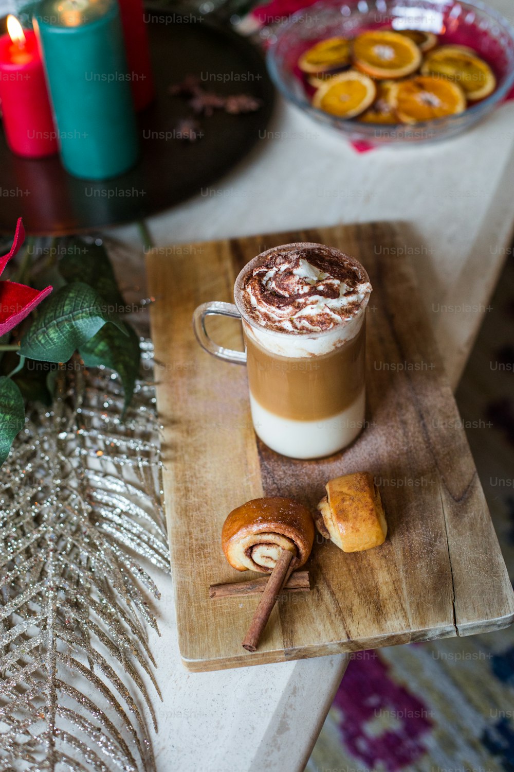 a cup of hot chocolate with a cinnamon roll on a cutting board